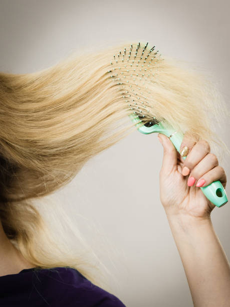 istock Unrecognizable blonde woman brushing hair 892801044