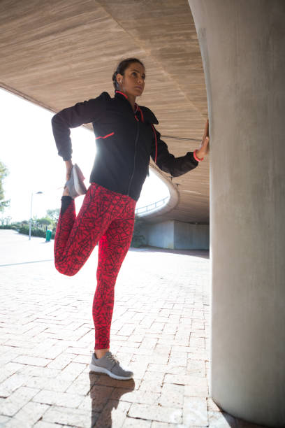 istock Fit woman doing stretching exercise with support of pillar 892801180