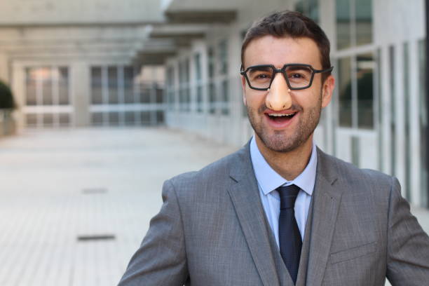 Businessman wearing fake nose-glasses combo Businessman wearing fake nose-glasses combo. groucho marx disguise stock pictures, royalty-free photos & images