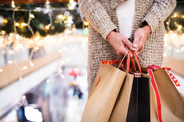 donna anziana con borse che fanno shopping natalizio. - fare spese foto e immagini stock