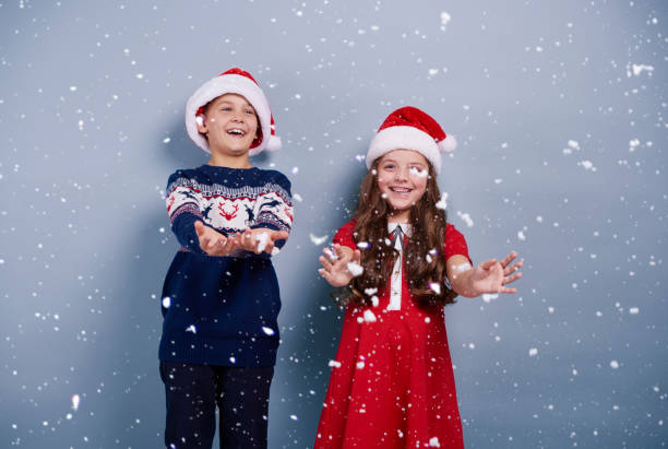 istock Girl and boy catching snwoflakes 892812794