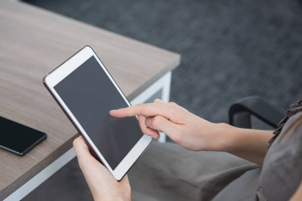 istock Mid section of female executive using digital tablet at table 892815728
