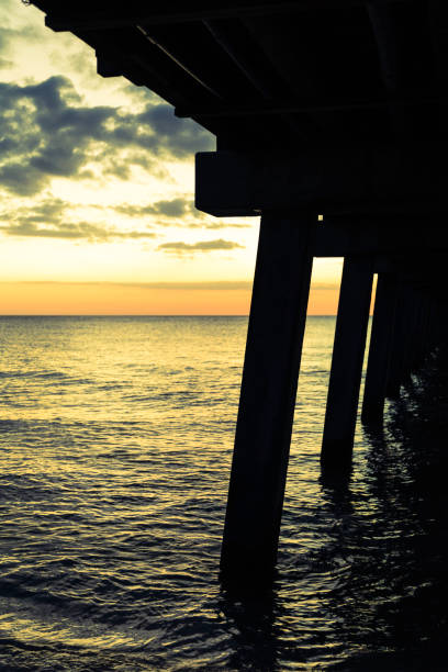 istock Golden Naples beach pier at dusk 892821554