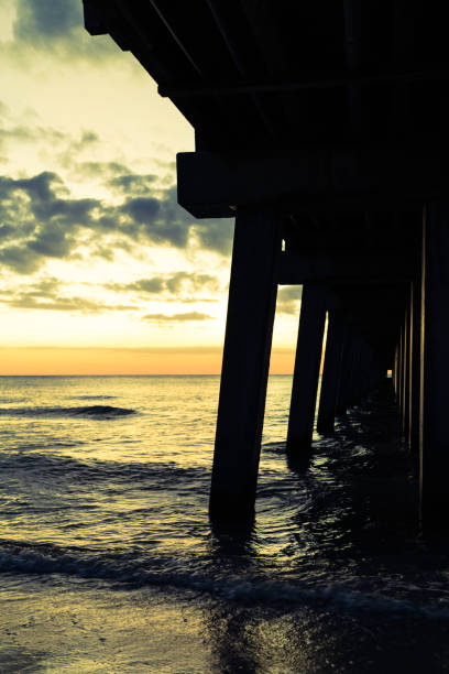 istock Golden Naples beach pier at dusk 892821608