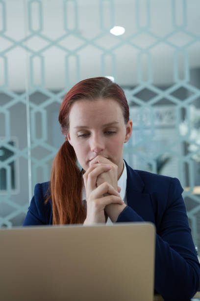 istock Thoughtful businesswoman using laptop at desk 892826668