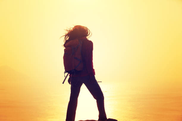 istock freedom woman with backpack standing on sunrise windy coast 892827462