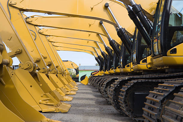 Earth Movers row of excavators construction machinery stock pictures, royalty-free photos & images