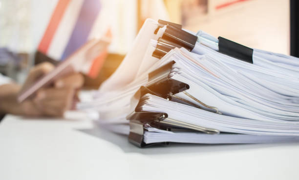 Paper stack, Pile of unfinished documents on office desk related to business functions. Stack of business papers for Annual Report files on blur National flag,use smart phone. Business offices concept pila de papel, pila de documentos sin terminar en escritorio de oficina relacionadas con las funciones del negocio. negocio papeleria archivos del informe anual en desenfoque de bandera nacional, uso de teléfono inteligente. concepto del negocio de oficinas