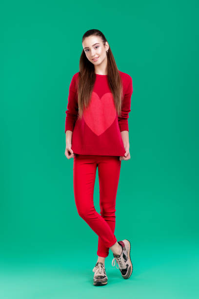 istock woman in red sweater on green background 892830052