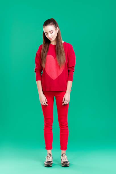 istock woman in red sweater on green background 892830406