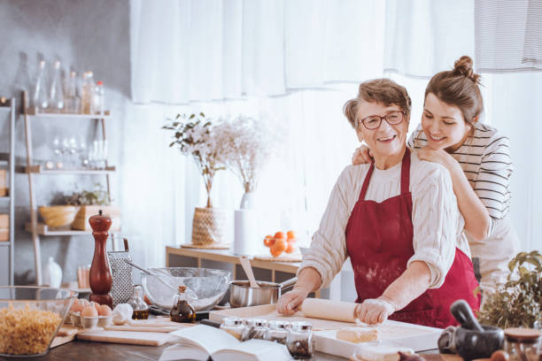 senior woman in kitchen apron - grandmother cooking baking family imagens e fotografias de stock