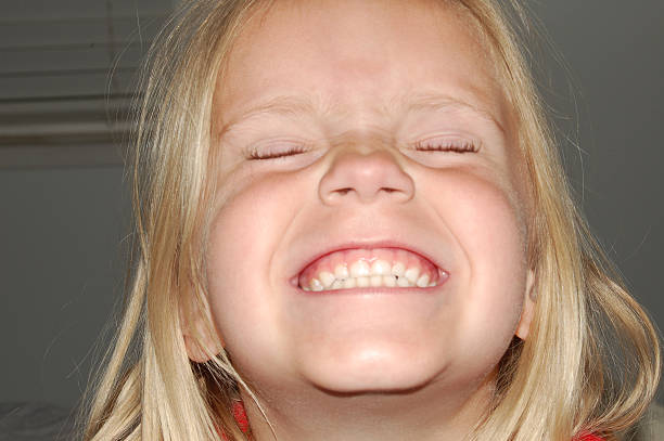 Little blonde girl with a cheesy smile stock photo