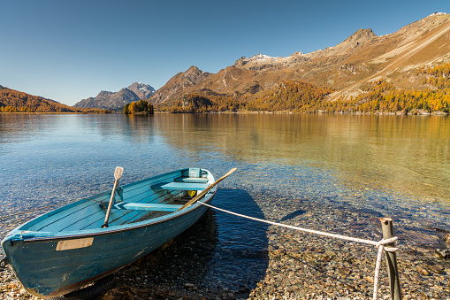 Old rustic wooden rowboat on the shores of the Lake of Sils_maria near St. Moritz in the Engadin Valley on a gorgeous autumn day