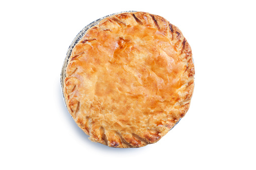 Overhead view of a single cooked meat pie complete with foil packaging cut out against a white background.