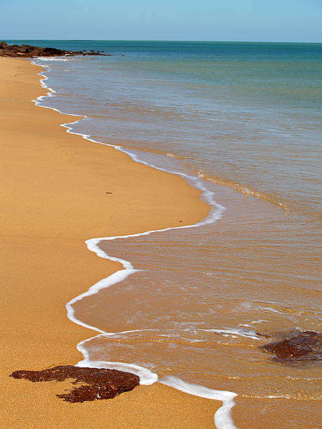 vagues pour la nage en longueur sur une plage de sable jaune - northern territory australia beach wilderness area photos et images de collection