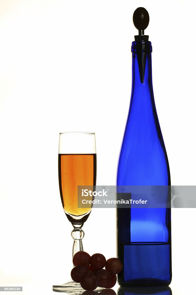 Azul, una botella de vino, uvas y gafas - Foto de stock de Alcoholismo libre de derechos