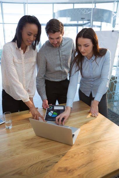 istock Business colleagues using laptop in conference room 892853902