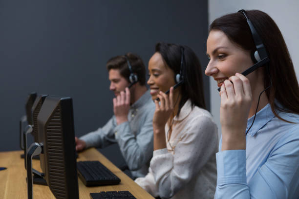 istock Business executives with headsets using computers at desk 892854114