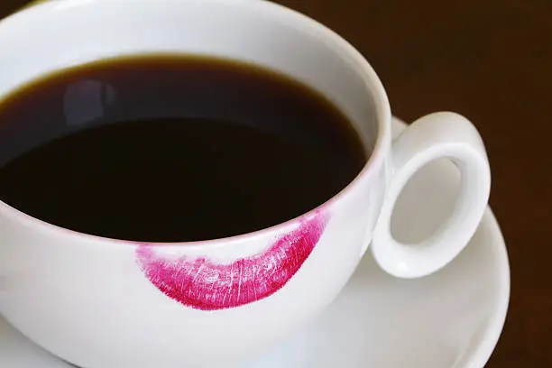 close-up red lipstick trace on a white coffee cup