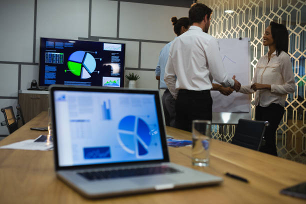 istock Female executive shaking hands with male executives 892856364