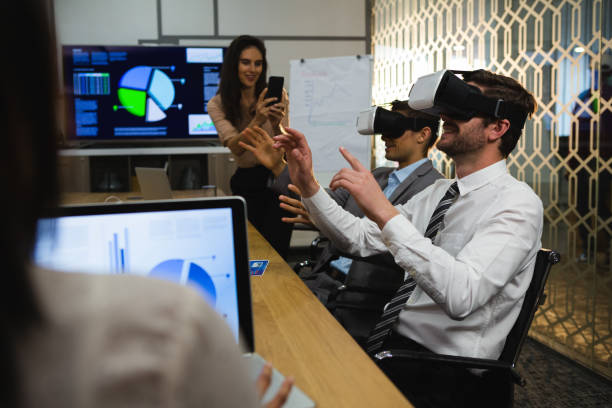 istock Businessmen using virtual reality headset in conference room 892857690