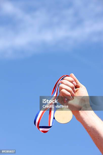 Hand Die Goldmedaille Gegen Blauen Himmel Stockfoto und mehr Bilder von Anreiz - Anreiz, Auszeichnung, Blau