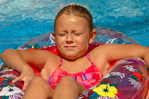 jeune fille se détend au coucher de soleil sur la piscine - inflatable ring water wings swimming pool float photos et images de collection