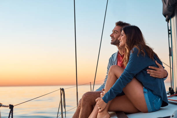 Take to the seas for a life of ease Shot of a young couple enjoying a cruise out on the ocean yachting stock pictures, royalty-free photos & images