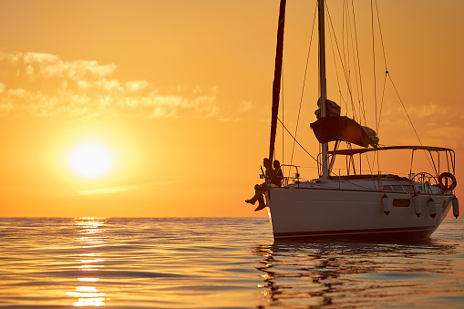 Shot of a young couple going for an ocean cruise at sunset