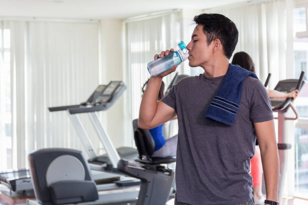 Happy healthy man are drinking water in the gym.After the exercise. stock photo