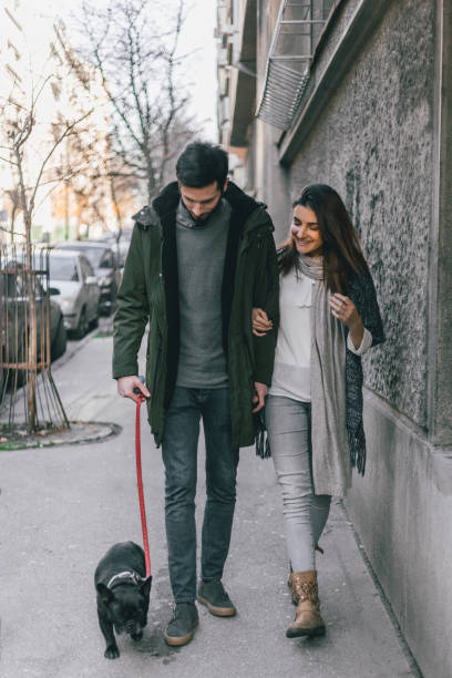 istock Young couple taking dog for a walk 892882894
