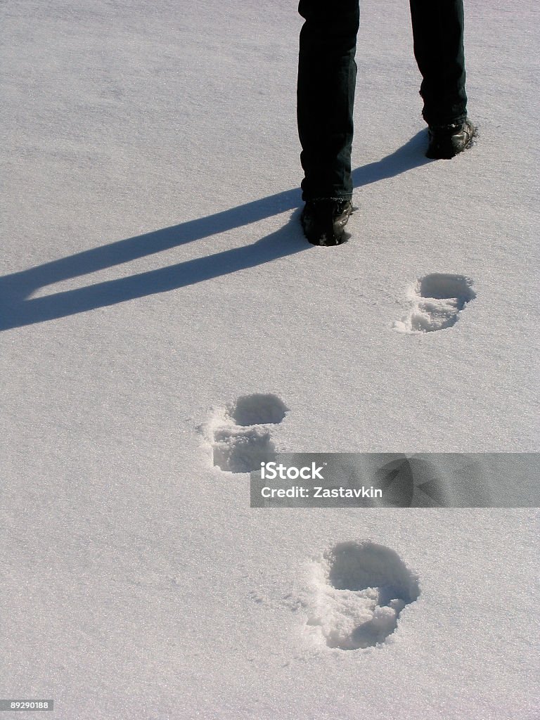 Uomo con gambe e impronta sulla neve - Foto stock royalty-free di Neve