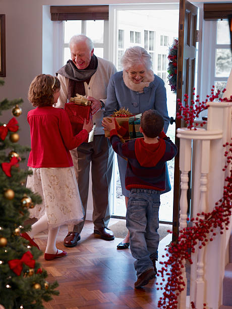 nonni e nipoti offrire regali di natale in ingresso - grandmother giving gift child foto e immagini stock
