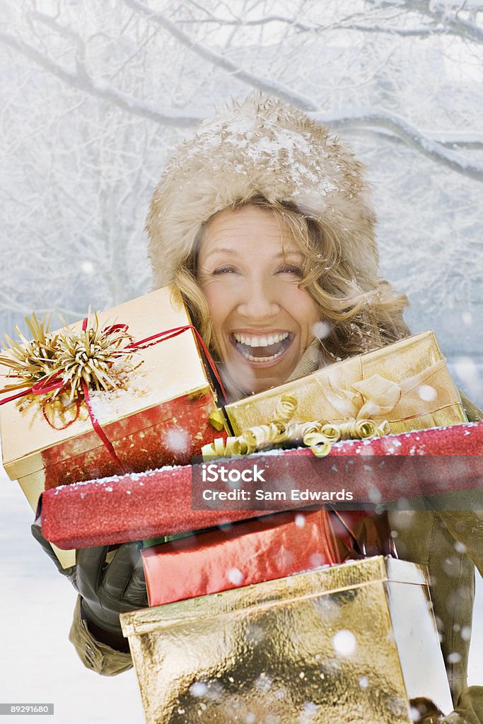 La neige tomber sur rire femme tenant des cadeaux de Noël - Photo de Cadeau libre de droits