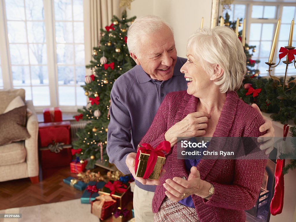 Mężczyzna zaskakujące kobieta z Boże Narodzenie prezent - Zbiór zdjęć royalty-free (Boże Narodzenie)