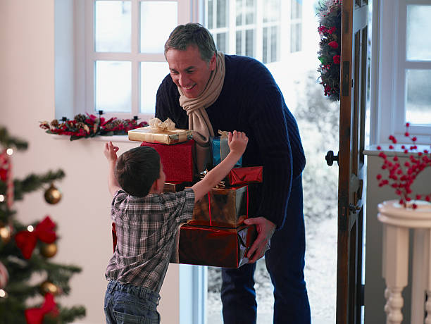 chłopiec z zadowoleniem przyjmuje ojciec gospodarstwa prezenty - home interior arrival father family zdjęcia i obrazy z banku zdjęć