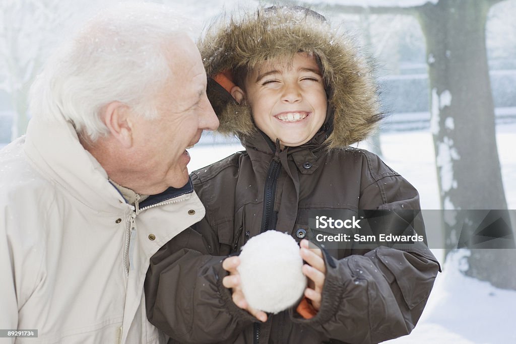 Dziadek i wnuczek Trzymając Śnieżka - Zbiór zdjęć royalty-free (Śnieg)