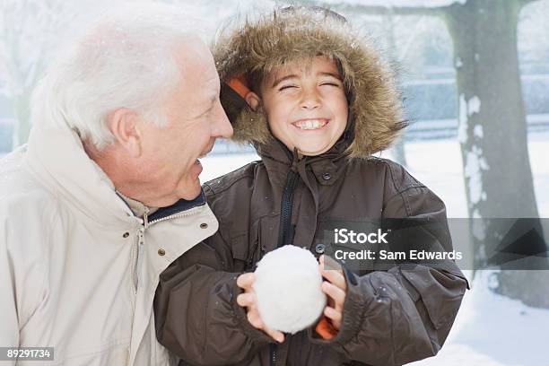 Foto de Avô E Neto Segurando Bola De Neve e mais fotos de stock de Neve - Neve, Criança, Terceira idade