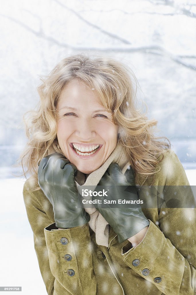 Snow falling on Mujer sonriendo - Foto de stock de Invierno libre de derechos