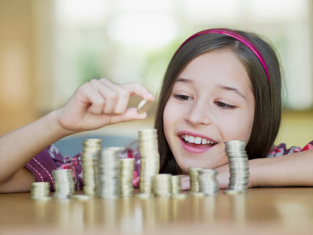 mädchen stapeln von münzen - currency savings coin counting stock-fotos und bilder