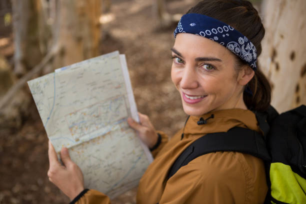 istock Young hiker woman with backpack holding a map in the forest 892918574