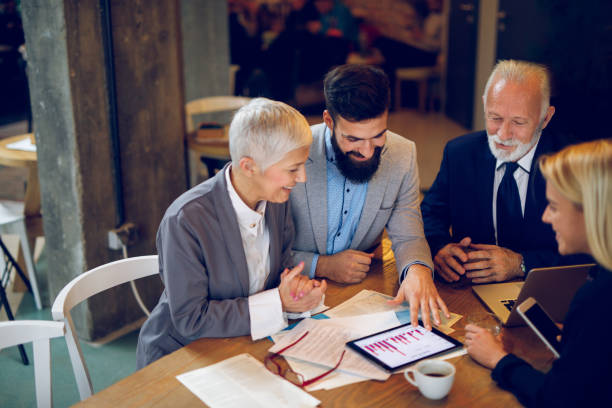 istock Mixed age business team having a meeting in cafe. 892919602