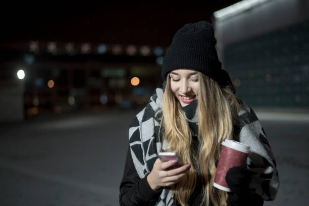 istock Young woman with coffee using her cellphone on the street 892931674