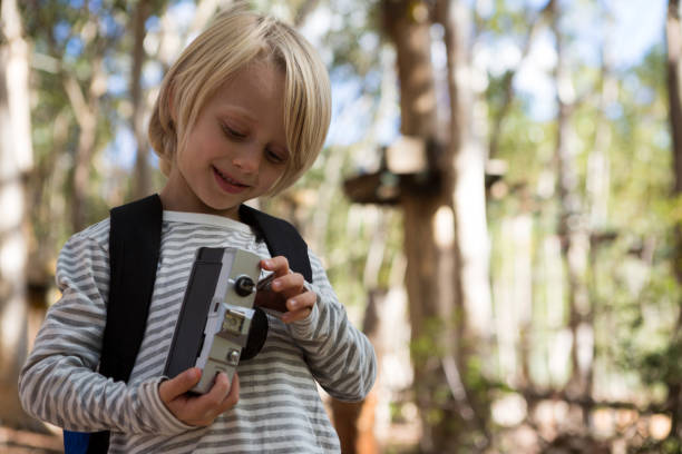 istock Little girl with a backpack holding camera in her hand 892945006