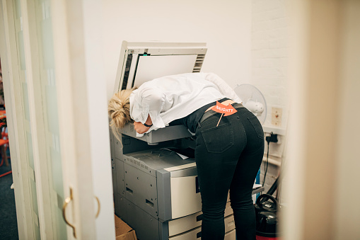 Mischievous business woman photocopying her chest.