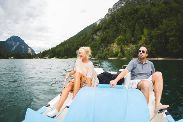 istock Two young people riding in a paddleboat, looking at view, Dolomites, Italy 892953326