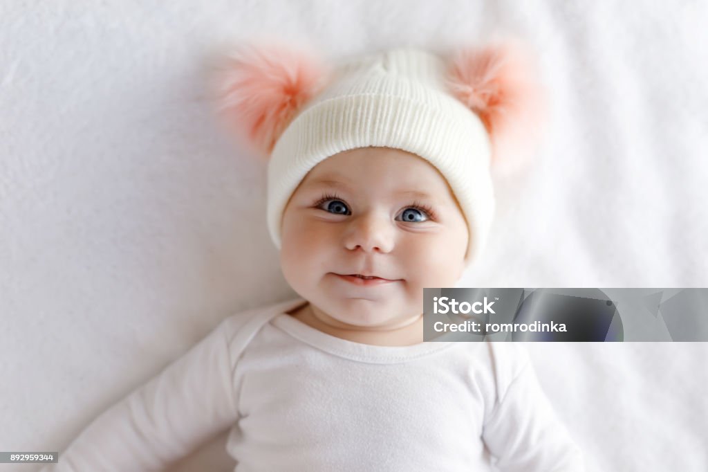 Criança bebê adorável bonito com chapéu branco e rosa quente com giros bobbles - Foto de stock de Bebê royalty-free