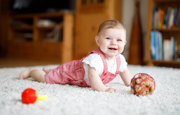 カラフルなラトル教育おもちゃで遊ぶかわいい赤ちゃん。小さな女の子、カメラ目線とクロール - portrait germany party bed ストックフォトと画像