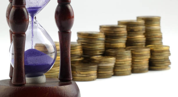 istock Hourglass and coins isolated on white background 892967738