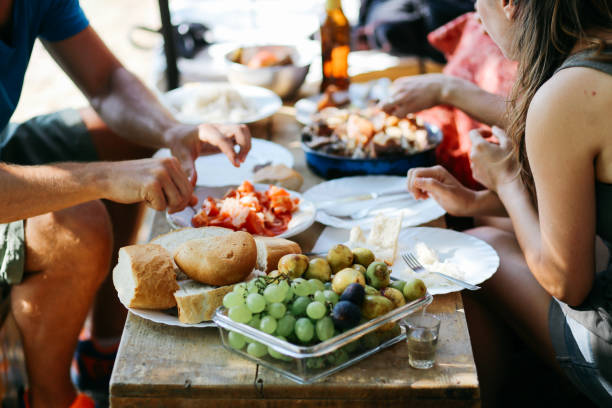 istock Young people eating outdoors 892968602